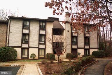 11627 Stoneview Square, Unit 21C Reston, VA 20191 - Photo 1 of 19 a front view of a house with large trees