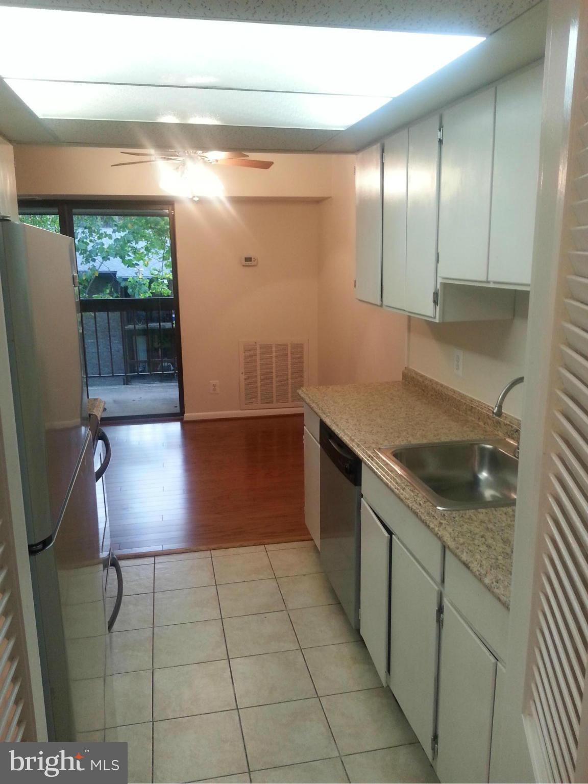 11627 Stoneview Square, Unit 21C Reston, VA 20191 - Photo 12 of 19 a kitchen with granite countertop a sink a stove a washer and dryer