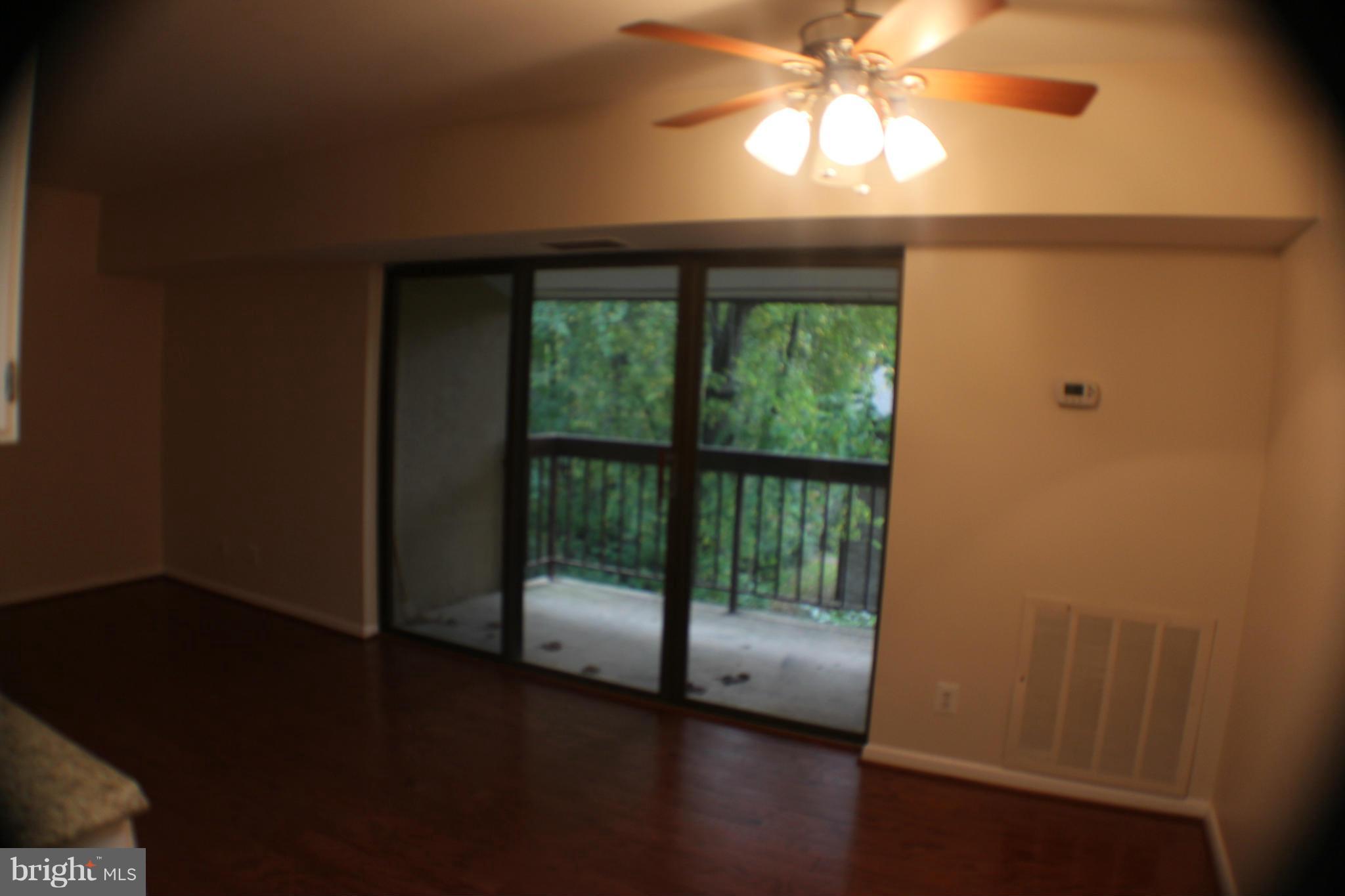 11627 Stoneview Square, Unit 21C Reston, VA 20191 - Photo 13 of 19 a view of empty room with wooden floor and fan