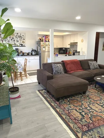 a living room with furniture and kitchen view