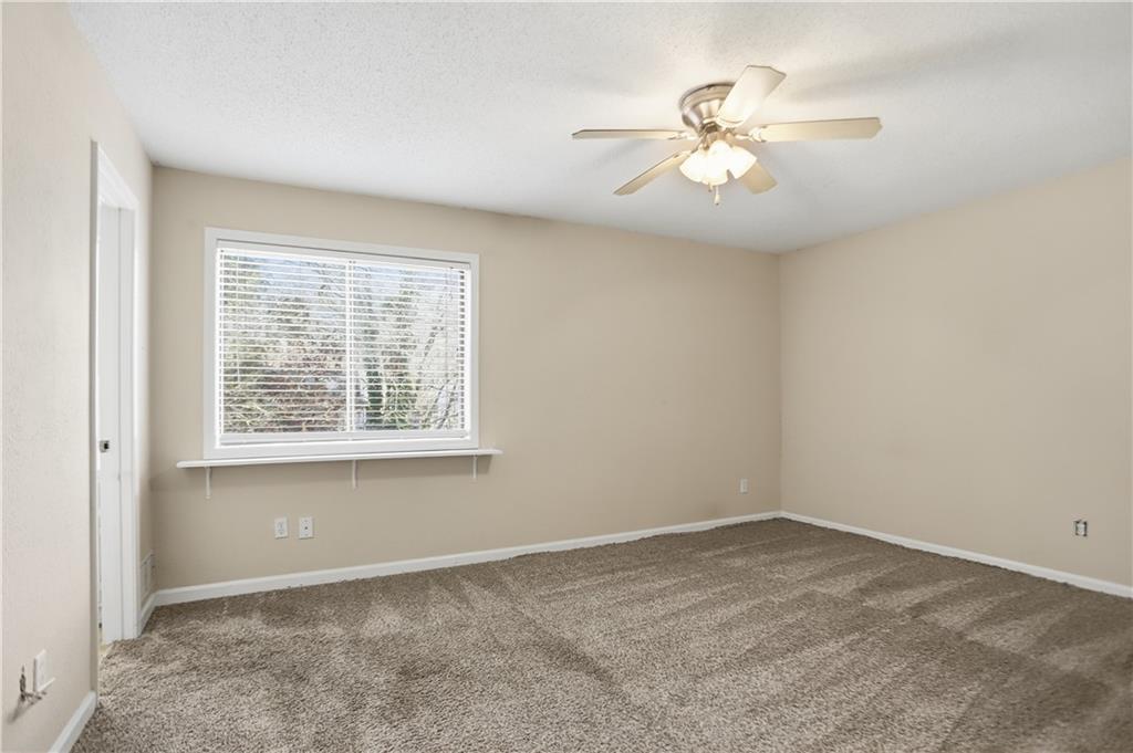4899 Hawk Trail Marietta, GA 30066 - Photo 18 of 35 an empty room with a window and a chandelier fan