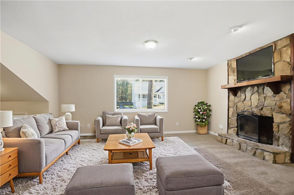 4899 Hawk Trail Marietta, GA 30066 - Photo 4 of 35 a living room with furniture a fireplace and a flat screen tv
