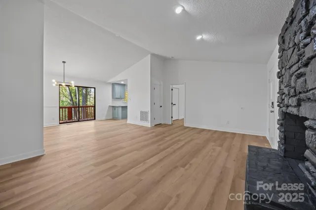 a view of an empty room with a fireplace and a window