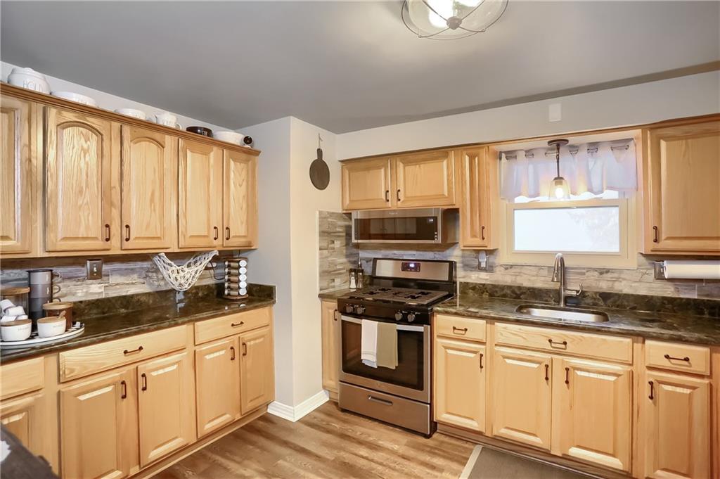 217 Lenore Drive McKees Rocks, PA 15136 - Photo 7 of 18 a kitchen with stainless steel appliances granite countertop a stove a sink and white cabinets