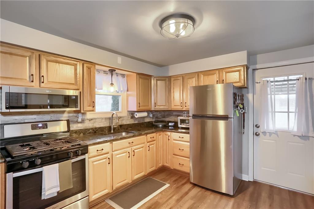 217 Lenore Drive McKees Rocks, PA 15136 - Photo 8 of 18 a kitchen with refrigerator a stove cabinets and wooden floor