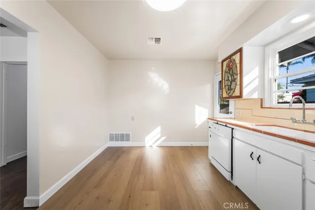 a hallway with wooden floor cabinets and a window