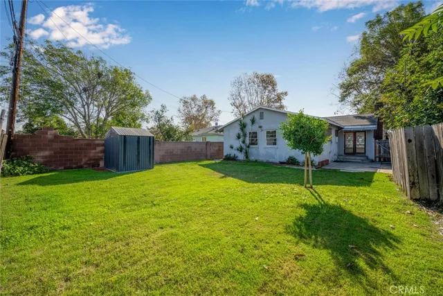 a view of an house with backyard and a tree
