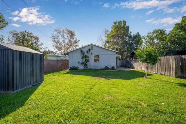 a view of a house with backyard and tree