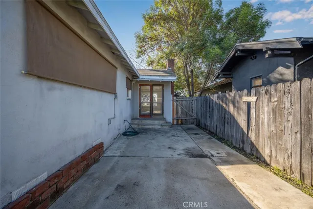 a view of backyard with large trees and wooden fence