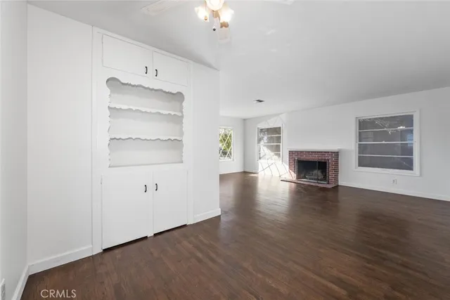 an empty room with cabinet and fireplace