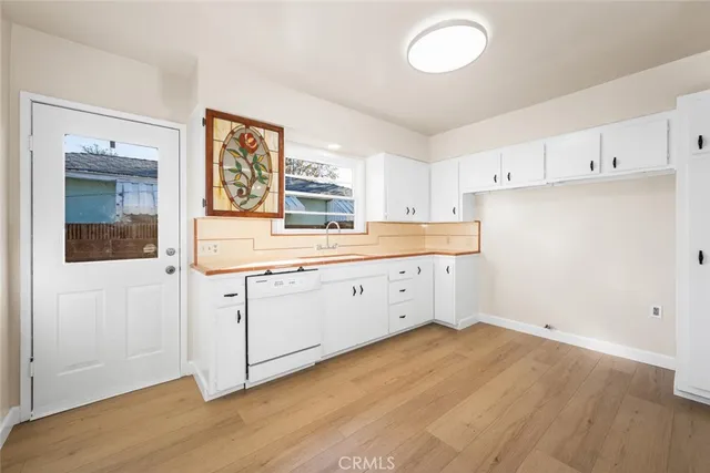 a kitchen with cabinets wooden floor and a sink