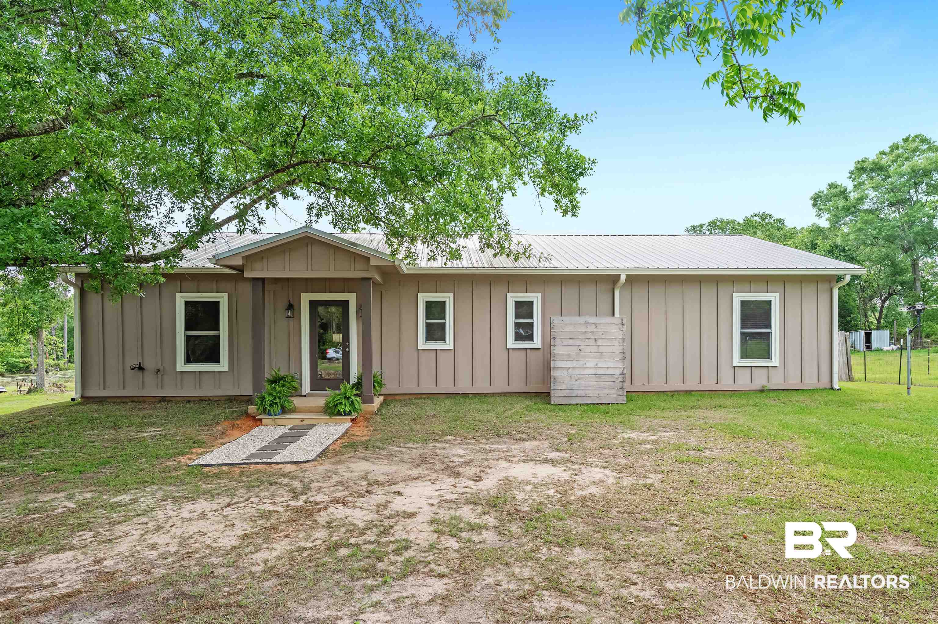 13827 County Road 83 Elberta, AL 36530 - Photo 4 of 38 Back of property with board and batten siding, a lawn, and metal roof