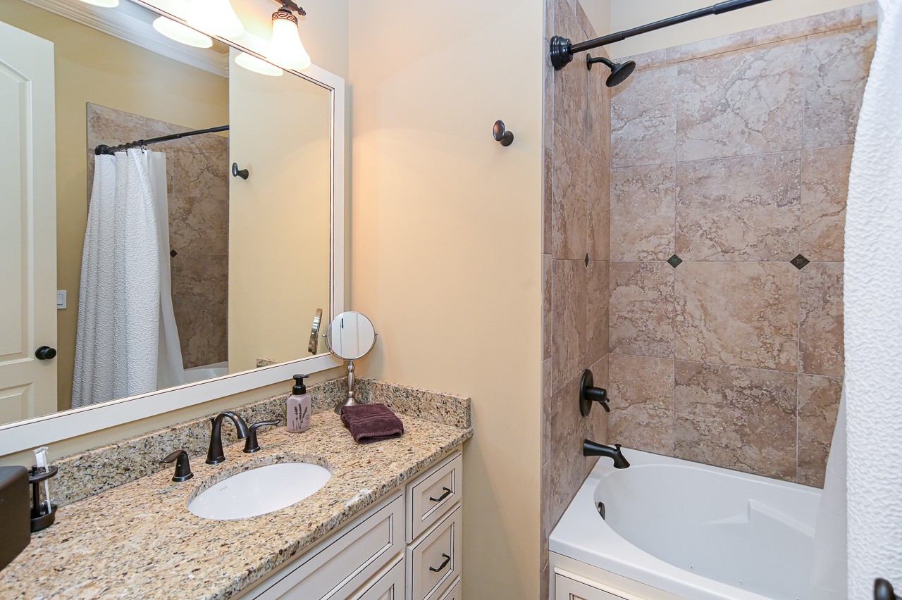 205 Nature Ridge Road Tullahoma, TN 37388 - Photo 31 of 58 a bathroom with a granite countertop sink a mirror a bathtub and shower