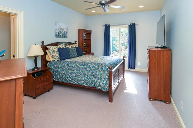 a living room with furniture a flat screen tv and a chandelier