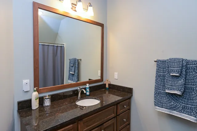a bathroom with a granite countertop sink and a mirror