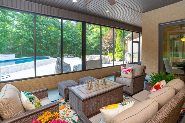 a view of a backyard with lawn chairs under an umbrella