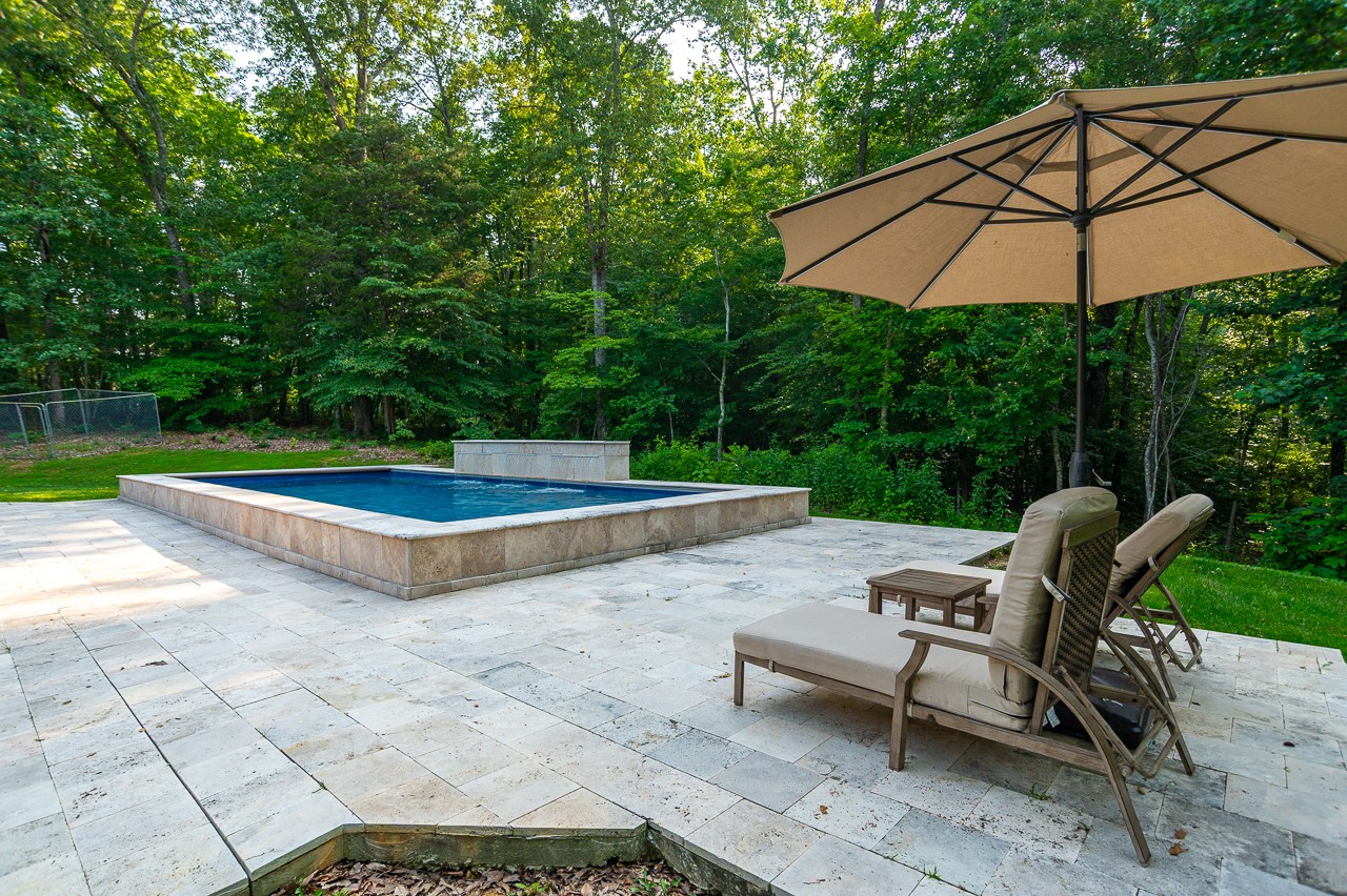 205 Nature Ridge Road Tullahoma, TN 37388 - Photo 51 of 58 a view of a backyard with lawn chairs under an umbrella