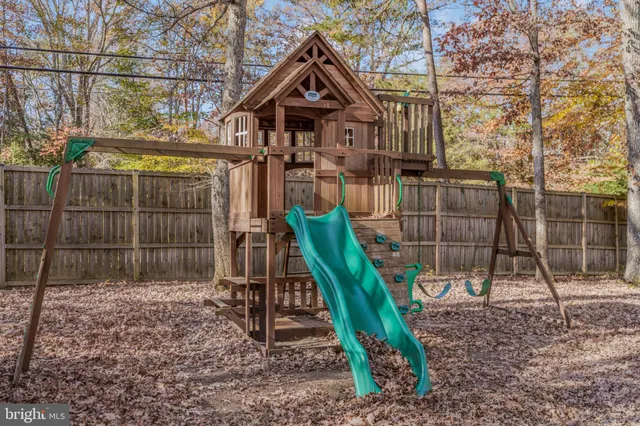 a view of a wooden house with a bench and wooden fence