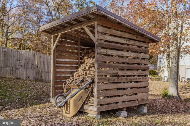 a view of a wooden house with a large tree and wooden fence