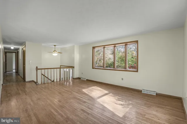 wooden floor in an empty room with a window