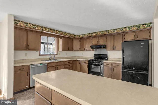 a kitchen with a stove a sink and a refrigerator