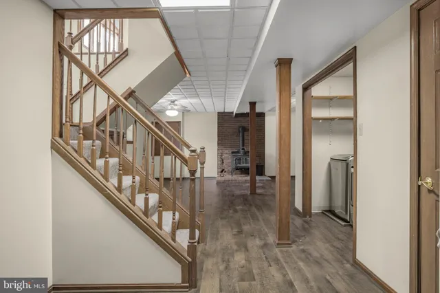 a view of staircase with wooden floor and white walls