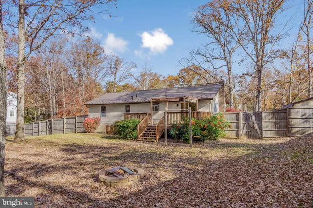 a view of a house with a yard and large tree