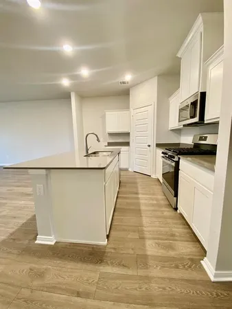 a large kitchen with kitchen island a sink a stove and a refrigerator