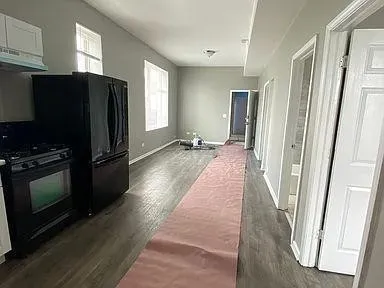 a view of a refrigerator in kitchen and windows