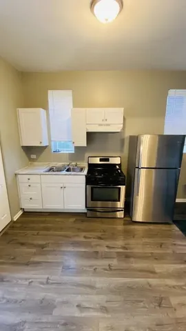 a view of a kitchen with wooden floor and a sink