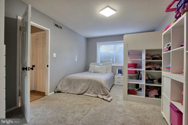 a bedroom with bed and two windows