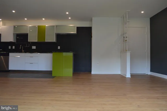 a view of a hallway with an empty space and entrance to other room