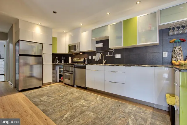a living room with furniture kitchen view and a refrigerator