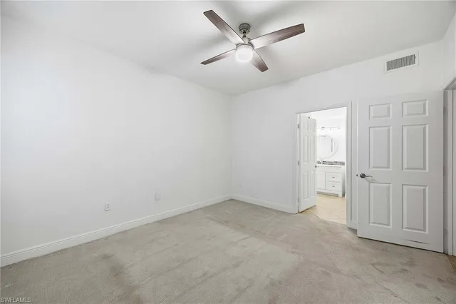 an empty room with closet and fan
