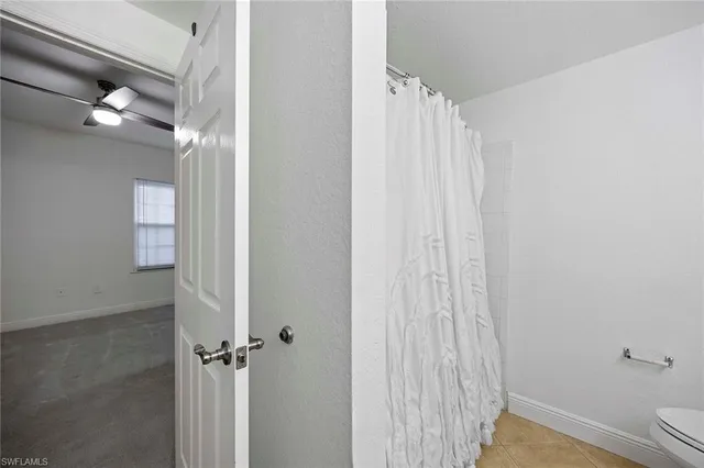 a bathroom with a shower curtain and a window