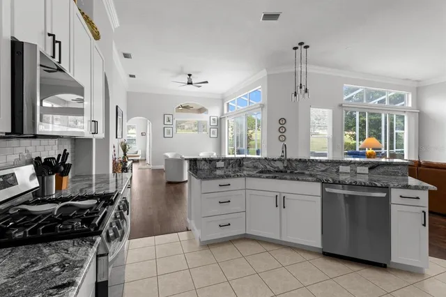 a kitchen with stainless steel appliances kitchen island granite countertop a refrigerator and a stove