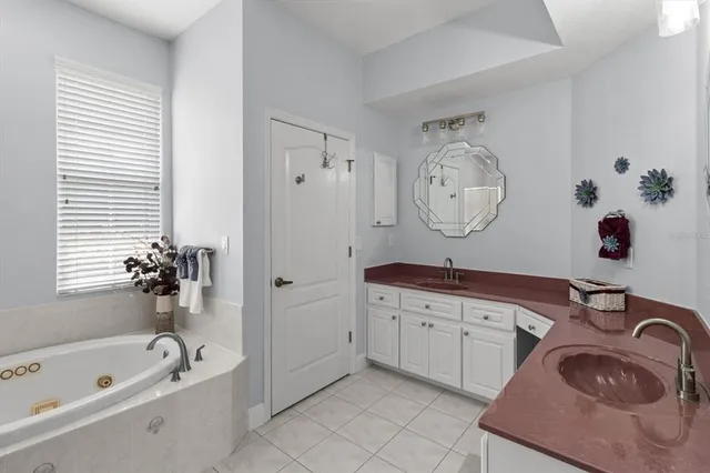a bathroom with a tub a window and shower