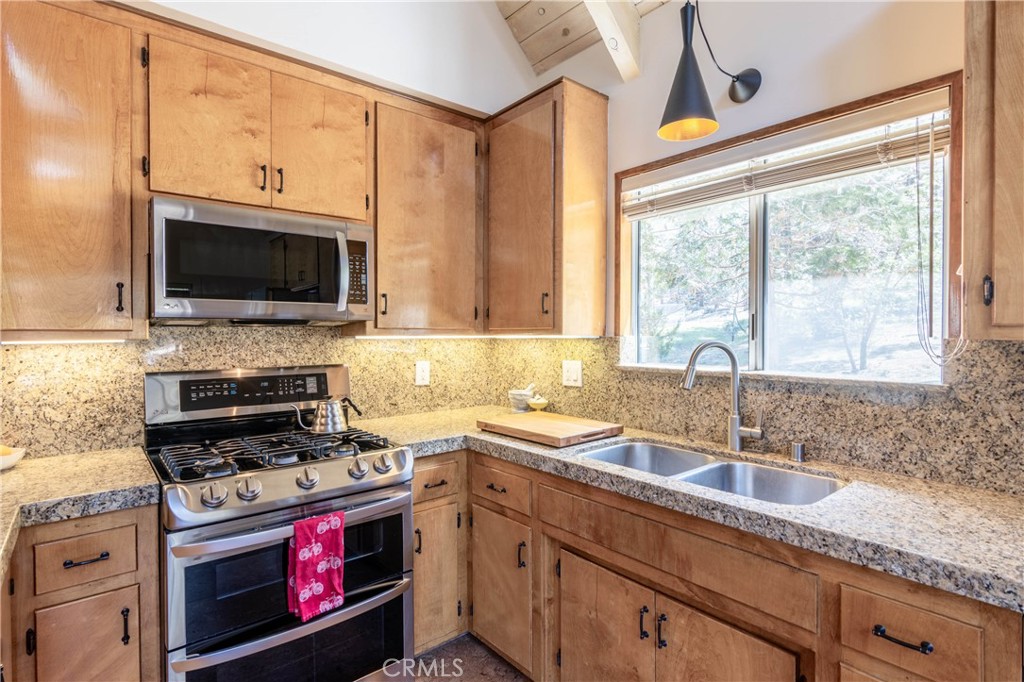 26704 Raven Road Wrightwood, CA 92397 - Photo 11 of 19 a kitchen with granite countertop a stove a sink and a microwave