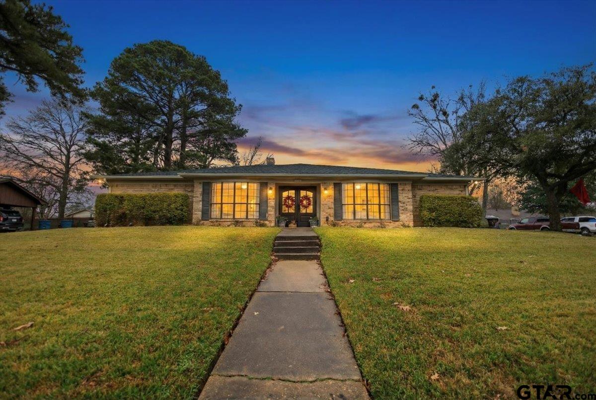 1606 Timothy Street Henderson, TX 75654 - Photo 1 of 33 a view of a brick house next to a yard with big trees