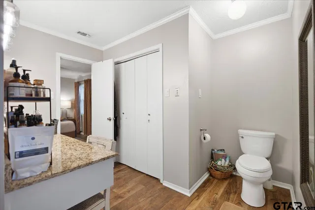 a large bathroom with a granite countertop toilet a sink and a mirror