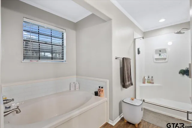 a white bath tub sitting next to a white toilet and vanity