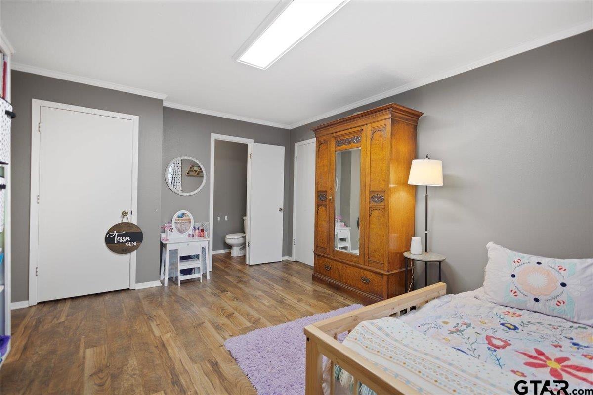 1606 Timothy Street Henderson, TX 75654 - Photo 27 of 33 a bedroom with a bed and wooden floor