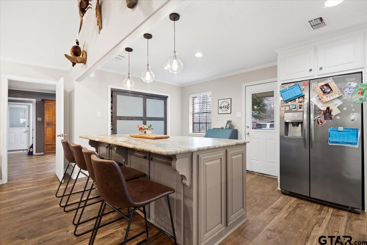 1606 Timothy Street Henderson, TX 75654 - Photo 4 of 33 a kitchen with stainless steel appliances granite countertop a refrigerator a sink dishwasher a dining table and chairs with wooden floor