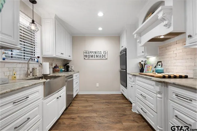 a kitchen with kitchen island granite countertop white cabinets and white appliances