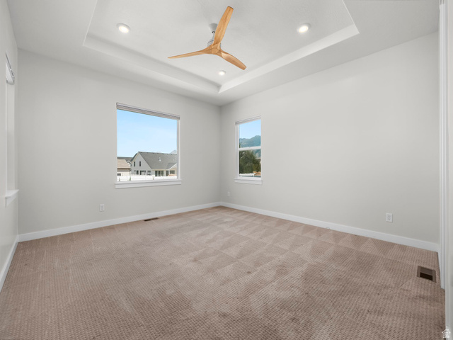 2786 West Hancock Street, Unit 198 Mapleton, UT 84664 - Photo 10 of 33 Spacious interior featuring a tray ceiling with recessed lighting, a contemporary ceiling fan, and two large windows