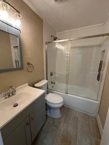 a bathroom with a sink a toilet a mirror and shower