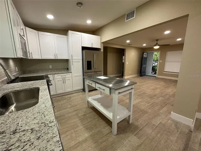 a kitchen with stainless steel appliances granite countertop a sink stove and refrigerator