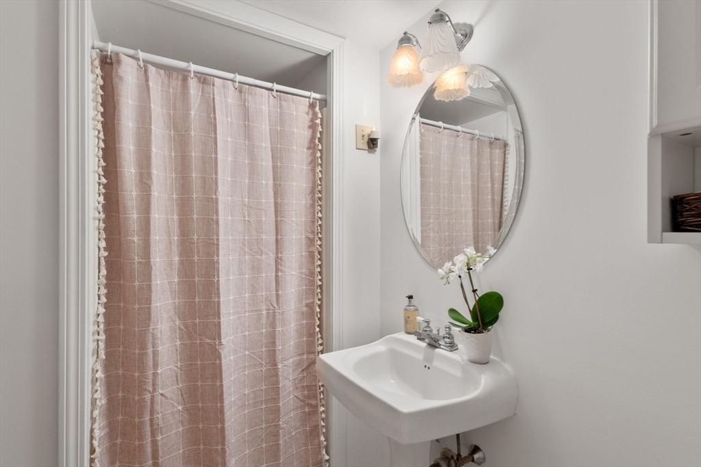 40 Cliff Road South Scituate, MA 02066 - Photo 14 of 30 a bathroom with a sink a mirror and a shower curtain