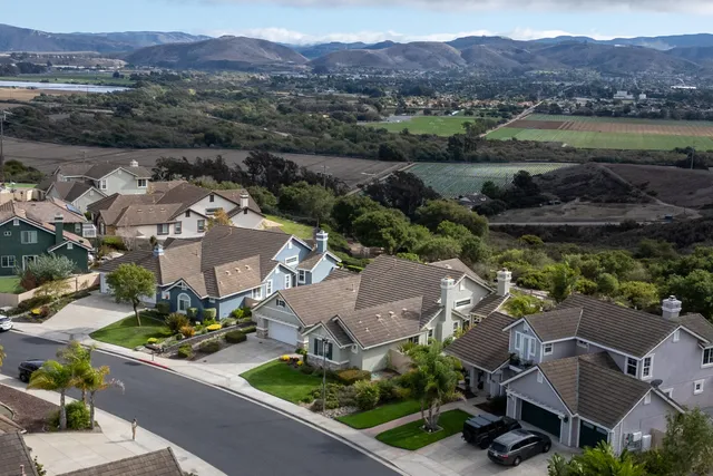 an aerial view of a house with swimming pool and outdoor seating