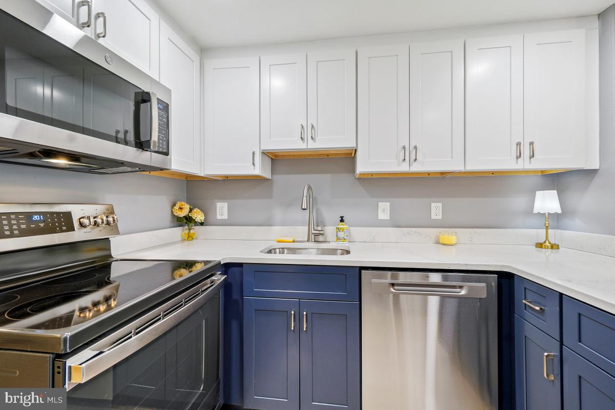 3362 Gleneagles Drive, Unit 711D Silver Spring, MD 20906 - Photo 2 of 26 a kitchen with a sink stove and cabinets